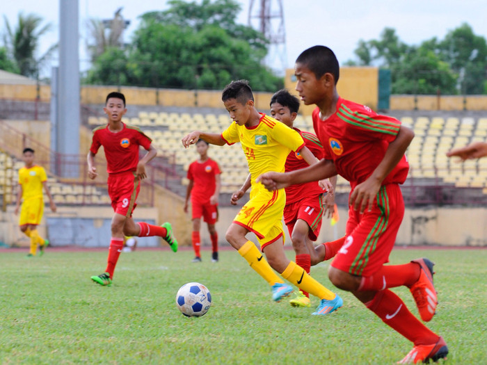Cầu thủ U13 SLNA tự tin cầm bóng trong vòng vây cầu U13 Bình Phước. Ảnh: Thành Cường