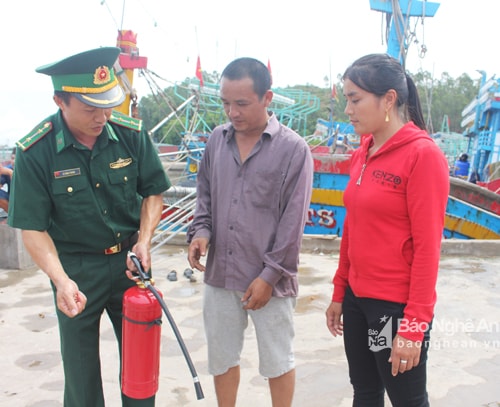 Bộ đội Biên phòng hướng dẫn cách sử dụng bình cứu hỏa cho bà con ngư dân huyện Quỳnh Lưu. Ảnh: Phương Thảo. 