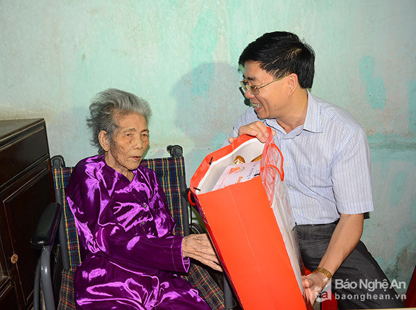 Phó Bí thư Tỉnh ủy Nguyễn Văn Thông thăm hỏi, động viên bà Nguyễn Thị Minh (90 tuổi) tại phường Long Sơn, Thị xã Thái Hòa. Ảnh: Thu Giang