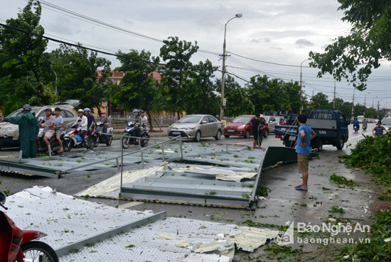 Mái tôn khổng lồ bay xuống đường cách đó khoảng hơn 200m. Sau bão, dân quân phường Hưng Dũng đang giải phóng mái tôn này