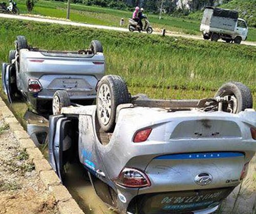 Hai chiếc xe bị lật ngửa dưới ruộng. Ảnh: Ngọc Linh.