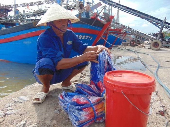 Ông Bùi Văn Mạo ở thôn Phong Thái, xã Tiến Thủy (Quỳnh Lưu)kiểm tra số lượng áo phao cho các thuyền viên lao động trên tàu của mình trước giờ ra khơi. Ảnh: Hồng Diện