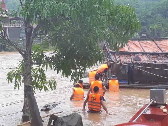 Cán bộ, chiến sỹ Ban CHQS huyện Tương Dương cùng cán bộ xã Tam Thái giúp dân neo buộc lồng nuôi cá trong lũ. Ảnh: Đình Tuân