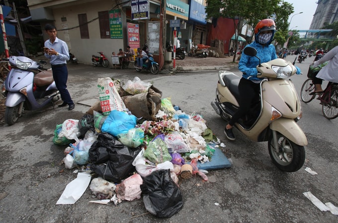 Hai bên phố Tân Mai có nhiều đống rác lớn nhỏ tập kết bên vệ đường.