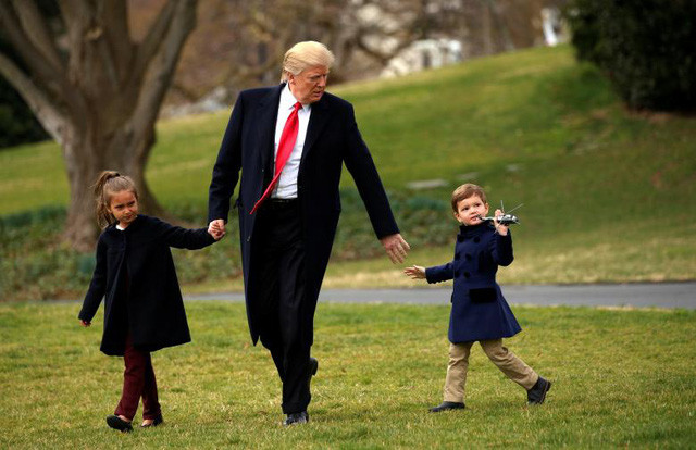 Ông Trump dắt tay cháu trai Joseph Kushner và cháu gái Arabella Kushner, con của Ivanka Trump và Jared Kushner, tại bãi cỏ ở Nhà Trắng.
