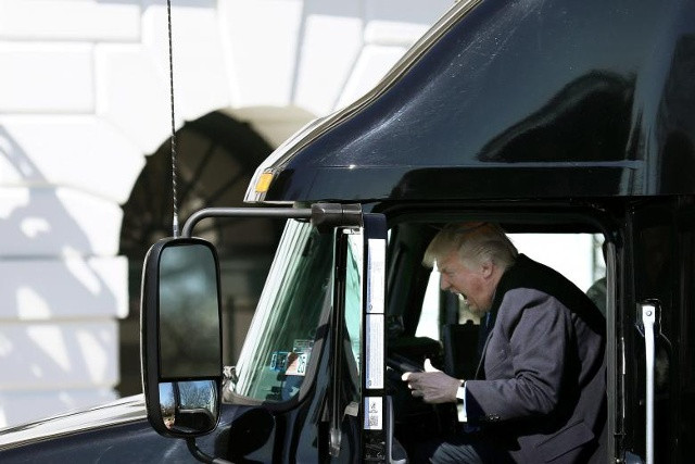 Tổng thống Donald Trump phản ứng khi ông ngồi trên một chiếc xe tải trong khi ông hoan nghênh các lái xe tải và giám đốc điều hành tham dự một cuộc họp về chăm sóc sức khoẻ tại Nhà Trắng ngày 23 tháng 3 năm 2017