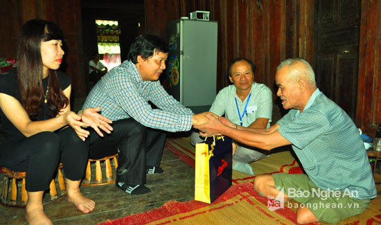 Đoàn cán bộ Ngân hàng nhà nước đến thăm hỏi, động viên và trao quà cho thương bình Lô Văn Du ở bản Huổi Xén, xã Yên Na, Tương Dương. Ảnh: Nguyễn Hải