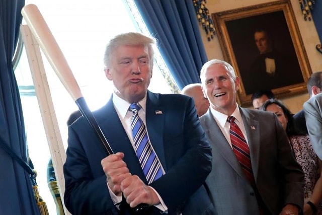 Phó Tổng thống Mike Pence cười khi Tổng thống Trump cầm một cây gậy bóng chày khi họ tham dự một sự kiện giới thiệu sản phẩm Made in America tại Nhà Trắng