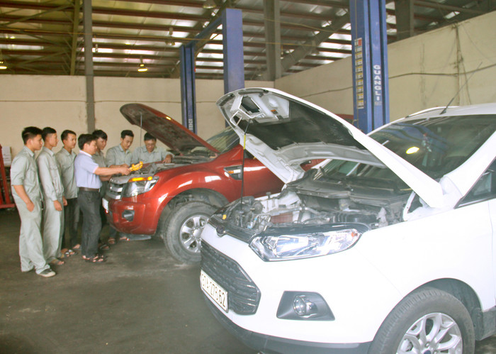 Giảng viên và học viên bảo dưỡng xe tại xưởng số 1, Trung tâm dịch vụ của nhà trường. Ảnh: Phương Hà