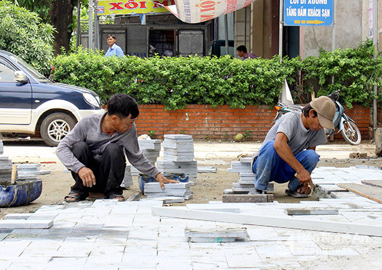 Người dân thị trấn Diễn Châu lát lại vỉa hè sau cưỡng chế giải tỏa. Ảnh Quang An