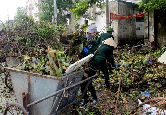 Công nhân Công ty TNHH MTV Môi trường đô thị Nghệ An tích cực thu dọn rác thải sau bão. Ảnh: Nguyên Nguyên