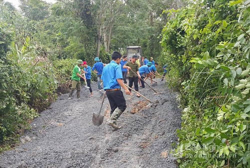 Đoàn viên thanh niên xã Tân Thắng hăng say san lấp mặt bằng và dọn dẹp vệ sinh tuyến đường vào gia đình vợ liệt sỹ Dương Thị Đàn ở xóm 19/8. Ảnh: Chu Diện