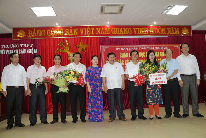 Các đồng chí lãnh đạo tỉnh và Hội Khuyến học tặng phần thưởng cho Ban giám hiệu Trường THPT Chuyên Phan Bội Châu. Ảnh: Mỹ Hà