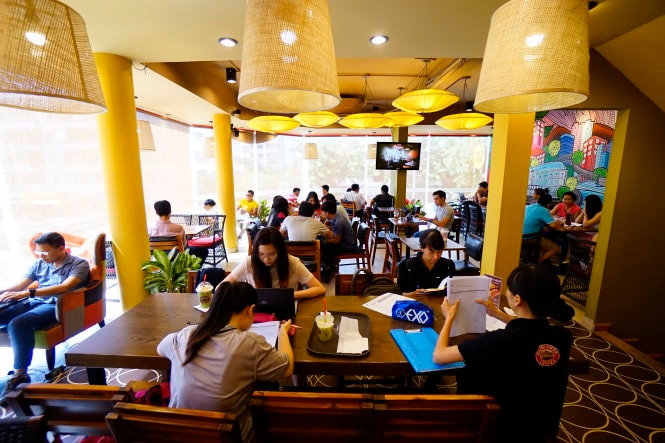Nhiều bạn trẻ làm việc trên máy tính tại một quán cà phê ở Q.Phú Nhuận, TP.Hồ Chí Minh. Ảnh: Quang Định