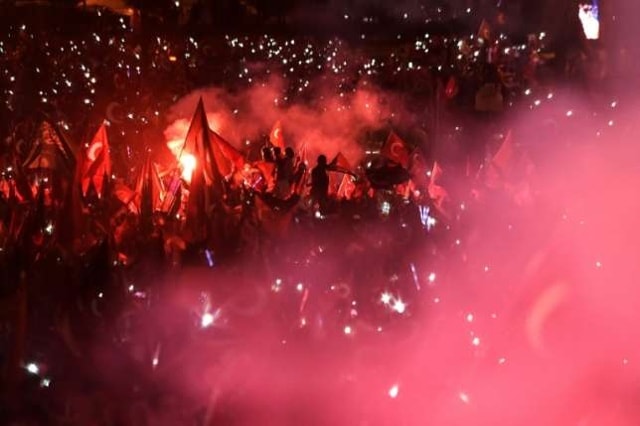 Người dân Thổ Nhĩ Kỳ vẫy cờ ủng hộ khi Tổng thống Tayyip Erdogan phát biểu sau 1 năm cuộc đảo chính bất thành. Ảnh: AFP.