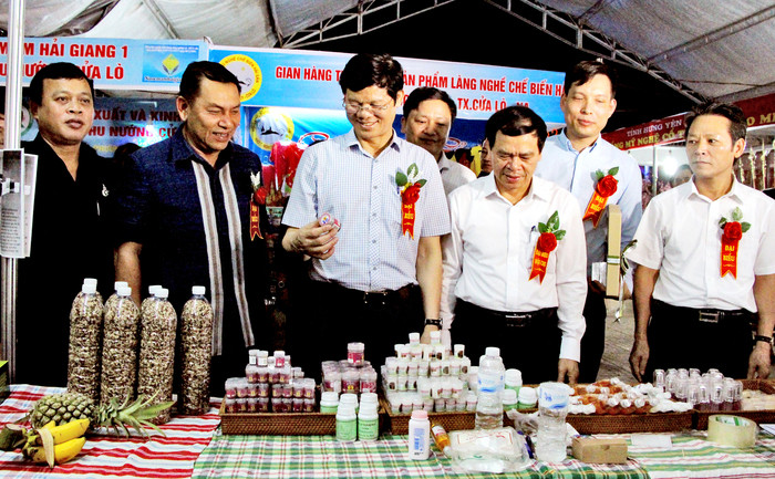 Đồng chí Lê Xuân Đại và lãnh đạo Sở  Công Thương tham quan các gian hàng Hội chợ thương mại Cửa Lò. Ảnh: Trân Châu