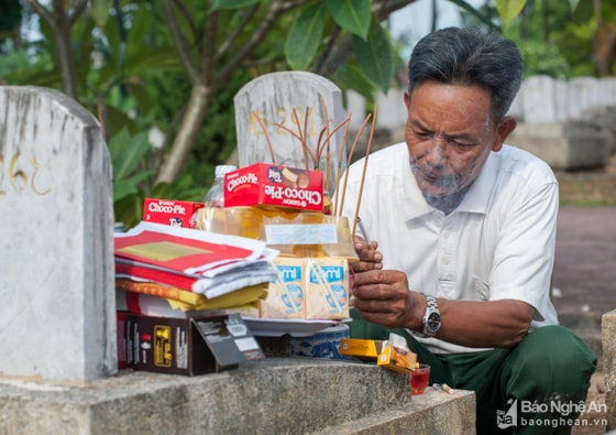 Giữa ngút ngàn hương khói ở Nghĩa trang Quốc tế Việt - Lào ở Anh Sơn, người cựu binh Trương Quang Liễu (xã Nghi Xuân, Nghi Lộc, Nghệ An) rưng rưng châm điếu thuốc cắm lên bình hương, rót chén rượu nồng mời người đồng đội từng được ông tự tay chôn cất ở chiến trường. Sau bao nhiêu năm qua đi, ông Liễu mới có thể tìm và thăm lại người đồng đội xưa nay đang nằm cùng gần 11.000 anh hùng liệt sỹ tại Nghĩa trang Quốc tế Việt Lào. Ảnh: Thành Cường