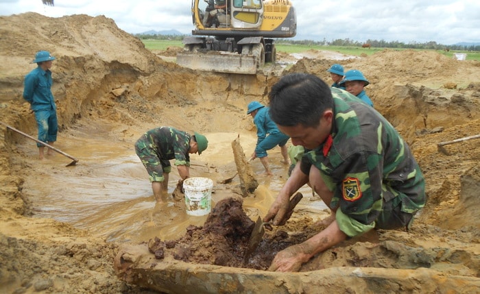 Lực lượng công binh gỡ các quả bom bi con trong vỏ bom mẹ. Ảnh: Nhật Tuấn