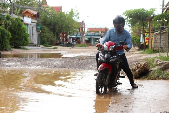 heo người dân cho biết, vào mùa mưa con đường này biến thành sông kéo dài hàng chục mét, hàng ngày xe trọng tải đi lại nhiều khiến hố sâu càng sâu hơn. Học sinh cấp 1, cấp 2 đi học chở nhau trên xe đạp thường xuyên bị ngã, ướt hết sách vở. Ảnh Việt Hùng