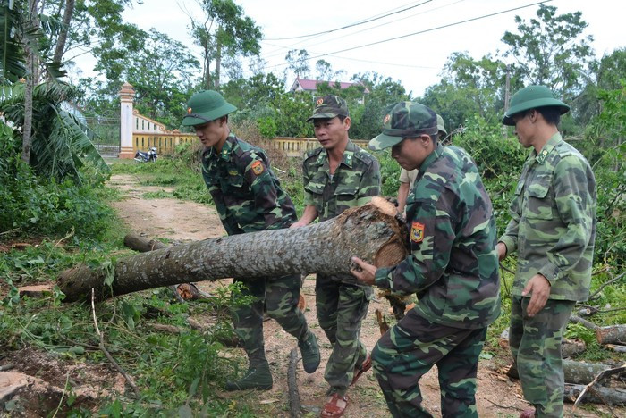 Tuổi trẻ Đồn BP Diễn Thành giúp đỡ nhân dân địa phương khắc phục hậu quả cơn bão số 2. Ảnh: Lê Thạch