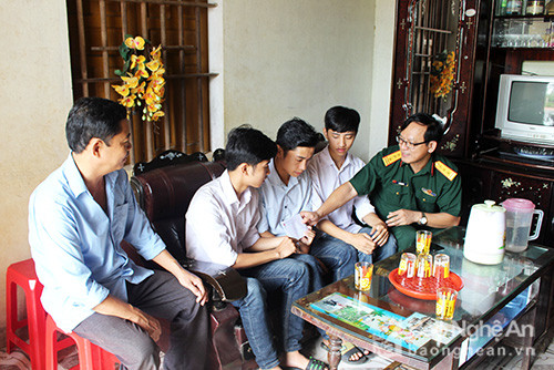 Thượng tá Trần Hoài, đại diện Báo Quân đội Nhân dân khu vực Bắc miền Trung trao quà cho ba anh em sinh 3. Ảnh: Huy Thư.