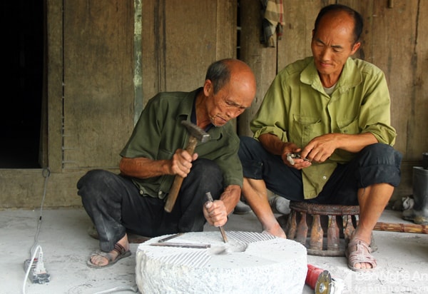 Đám cưới cụ Vừ được tổ chức hai năm trước, với 30 mâm cùng hơn 300 khách tới dự.Trong đó chủ yếu là con cháu của cụ. Trong ảnh, cụ Vừ cùng người con rể thứ 9 đục cối đá để xay lúa. Ảnh. Tiến Hùng.