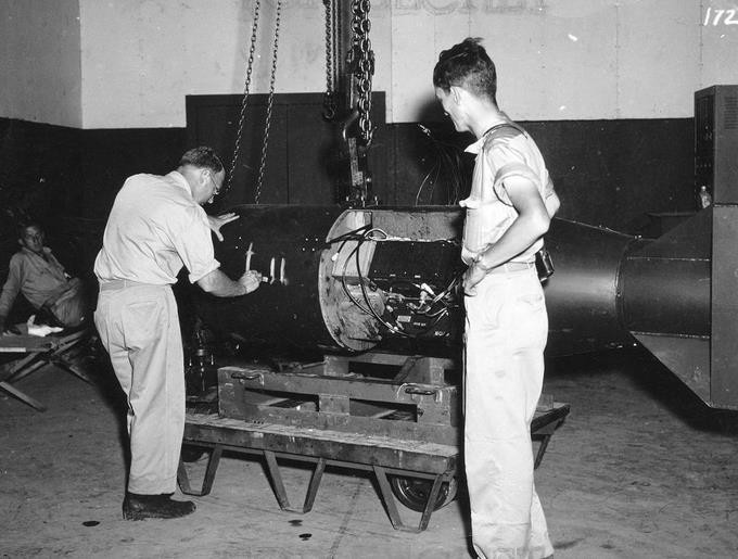 Nhà địa vật lý Francis Birch (bên trái), thành viên dự án Manhattan phát triển bom nguyên tử của Mỹ, đánh dấu vào quả bom Little Boy. Đứng cạnh ông là Norman Ramsey, người sau này giành giải Nobel Vật lý.