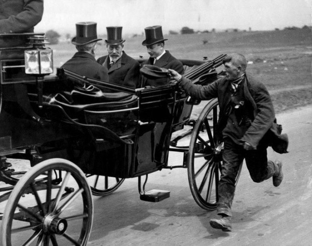Một người ăn xin chạy theo xe của vua George V năm 1920. 