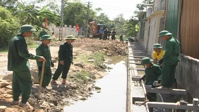 Cán bộ, chiến sĩ Tiểu đoàn 38 xây dựng mương thoát nước tại xóm 8 xã Hưng Trung. Ảnh: Hồ Việt