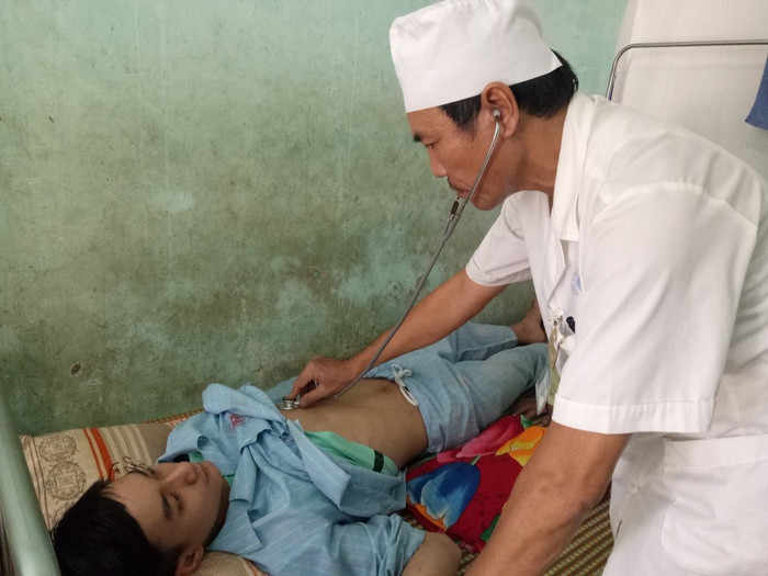 Bác sỹ Trần Minh Khổng - Trưởng khoa truyền nhiễm, Bệnh viện Đa khoa khu vực Tây Bắc Nghệ An thăm khám cho bệnh nhân sốt xuất huyết. Ảnh: Quang Huy