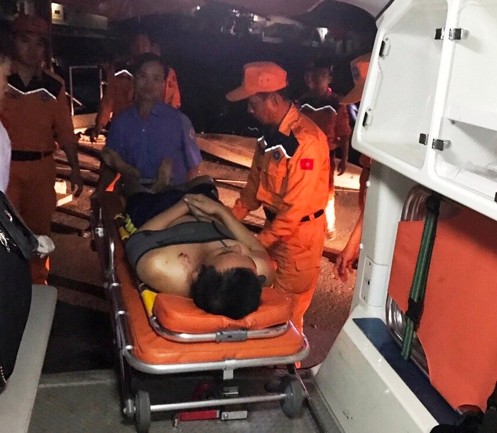 Đưa thuyền viên Nguyễn Văn Vương (27 tuổi, quê ở huyện Yên Thành, Nghệ An) từ tàu cứu nạn chuyên dụng CN02-TSA lên bờ. Ảnh: Nguyễn Duy Công.