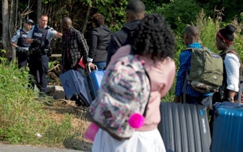 Một gia đình Haiti đối diện với cảnh sát Hoàng gia Canada khi họ vượt biên. Ảnh: Reuters