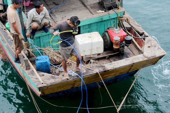 Người lặn giỏi nhất được trang bị dây khí ô xi trước khi lặn xuống biển tìm sắt. Ảnh: Nguyên Nguyên