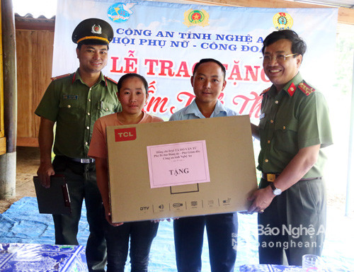 Đại tá Hồ Văn Tứ - Phó Bí thư Đảng ủy, Phó Giám đốc Công an tỉnh tặng quà cho gia đình chị Lầu Y Mái. Ảnh: 