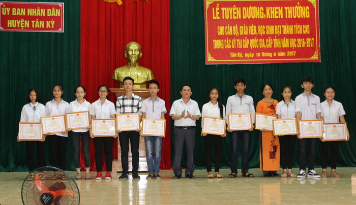 Đồng chí Trịnh Hữu Thành - Phó Chủ tịch UBND huyện Tân Kỳ trao tặng giấy khen cho các em học sinh đạt thành tích cao. Ảnh: Như Lành