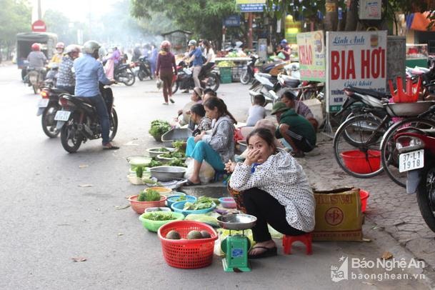 Hai bên lối vào chợ, người dân bàyhàng hóa lấn hẳn ra lòng đường để bán. Ảnh: Huy Thư