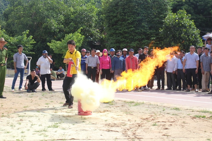 Các học viên thực hành dập tắt đám cháy bằng bình bột. Ảnh: Đình Tuân