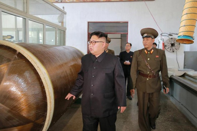 Ở hình ảnh này, ông Kim Jong-un đứng cạnh một thùng chứa màu đồng được cho là vỏ bọc tên lửa loại mới bằng nhựa gia cố bằng các sợi đan giúp tên lửa nhẹ hơn và bay xa hơn.