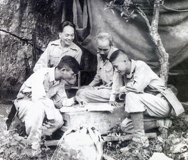 Chủ tịch Hồ Chí Minh cùng Đại tướng Võ Nguyên Giáp và Trung đoàn trưởng Thái Dũng, Tiểu đoàn trưởng Dũng Mã đang nghiên cứu sơ đồ tác chiến Chiến dịch Biên giới.