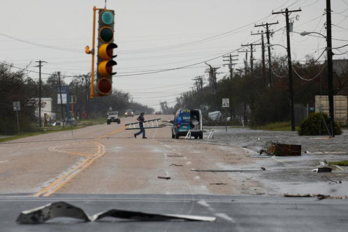 Một cư dân thu dọn những mảnh vỡ trên đường phố ở Rockport sau khi bão Harvey đi qua. Ảnh: Reuters