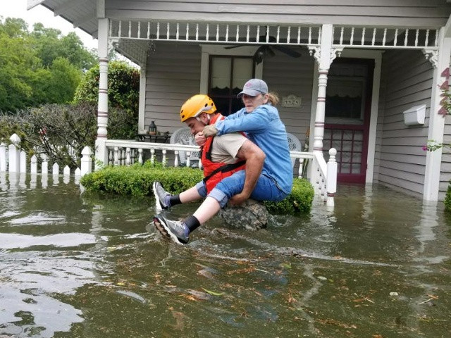 Một người lính canh Quốc phòng Texas mang một phụ nữ trên lưng khi họ tiến hành các hoạt động cứu hộ ở những vùng bị ngập nước xung quanh Houston, Texas