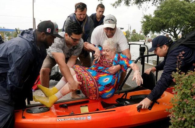 Sterling Broughton được chuyển từ một chiếc thuyền cứu hộ sang một chiếc thuyền kayak ở Dickinson, Texas. 