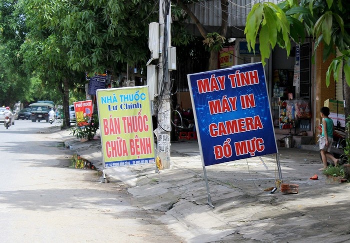 Nhiều của hàng tại đường Phong Định Cảng bê hẳn biển quảng cáo ra sát mặt đường. Ảnh: Quang An