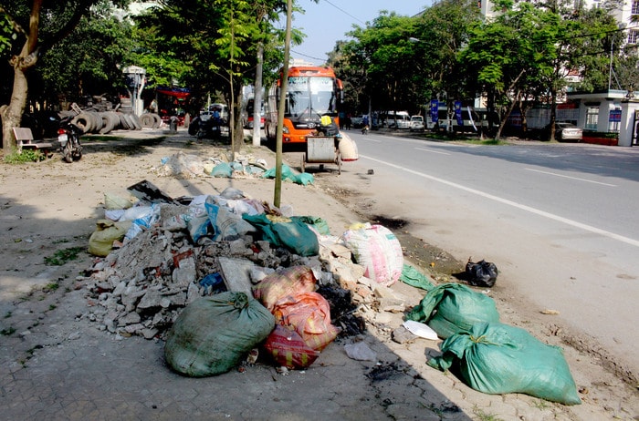 Không chỉ chiếm dụng vỉa hè làm nơi kinh doanh, đỗ xe, một số điểm trên tuyến đường Nguyễn Thái Học đã dùng vỉa hè làm nơi chứa rác, gây mất mỹ quan đô thị. Ảnh: Quang An