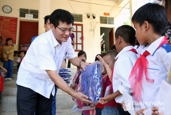 Đại diện huyện Tương Dương trao quà cho các em học sinh nghèo thuộc xã Hữu Khuông vào đầu năm học mới. Ảnh Sách Nguyễn 