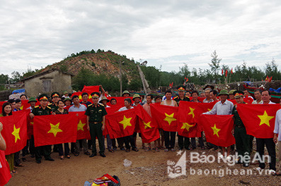 Đoàn thanh niện Bộ CHQS tỉnh và UBND huyện Nghi Lộc tặng cờ cho ngư dân xã Nghi Quang huyện Nghi Lộc. Ảnh: Trọng Kiên.