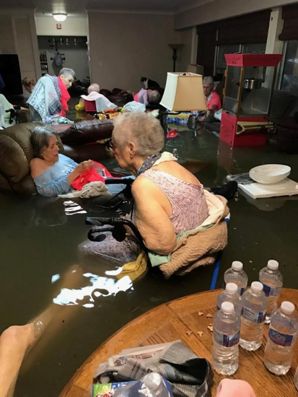 Các cụ bà trong nhà dưỡng lão ngồi trong căn phòng ngập nước