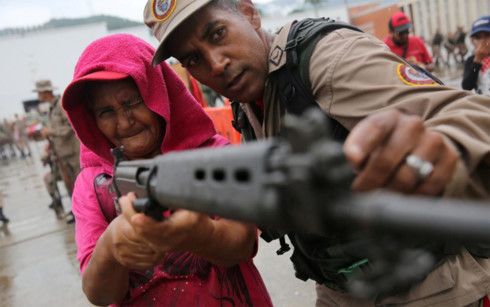 Binh sĩ Venezuela hướng dẫn người dân cách sử dụng súng. Ảnh: Reuters.