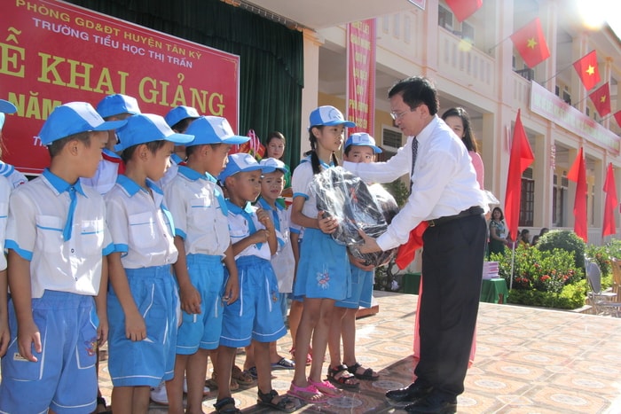 Thay mặt lãnh đạo tỉnh, đồng chí Đinh Viết Hồng tặng quà cho các cháu học sinh có hoàn cảnh khó khăn. Ảnh: Phương Hảo