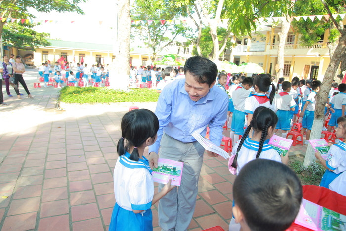 Ông Lê Sỹ Chiến, Phó chủ tịch UBND thành phố Vinh trao quà cho học sinh tiểu học Nghi Đức trong ngày tựu trường. Ảnh: Thiên Thiên